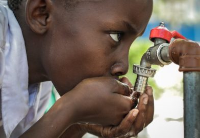 boy drinking from outdoor water facet